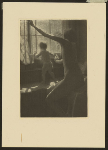 A gum print photograph of a nude woman and baby looking out a window. The woman appears to be opening the curtains.