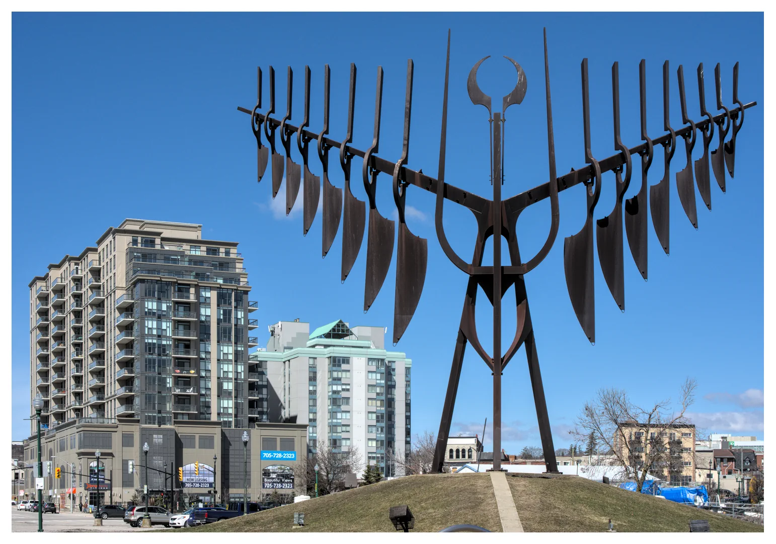 A photograph of Spirit Catcher on the Barrie Waterfront with a couple condo buildings in the background.