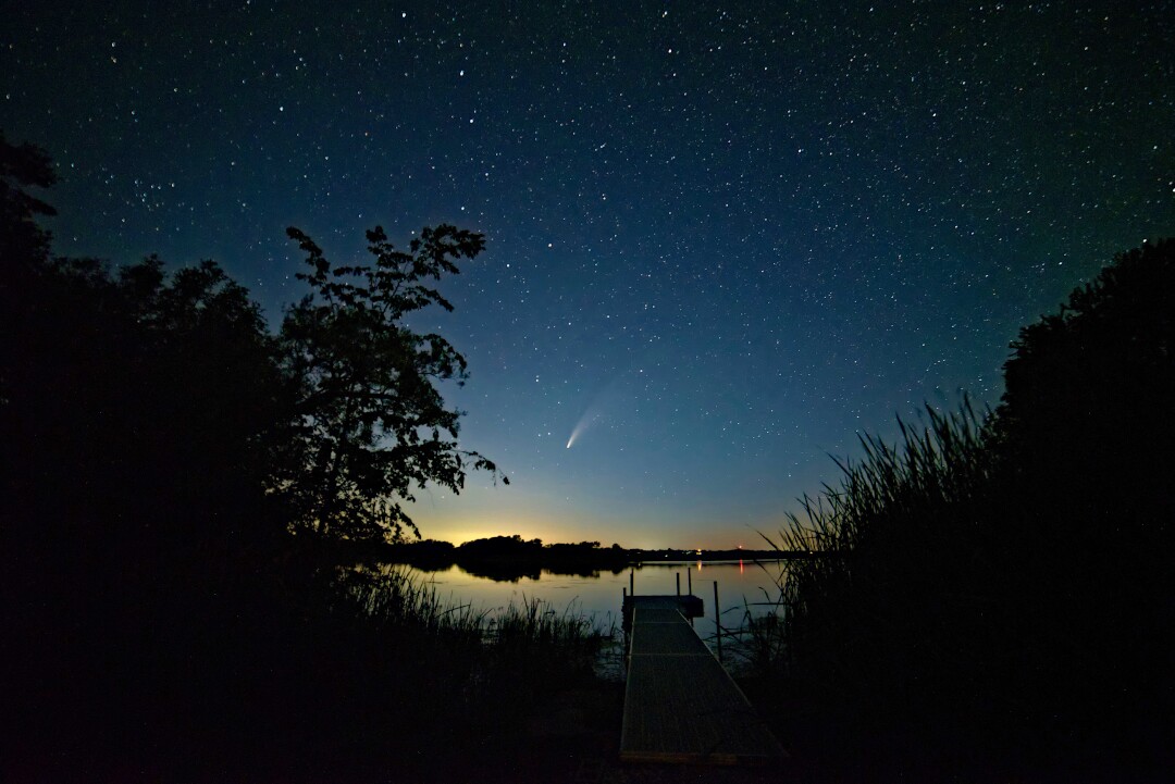 Comet Neowise in the night sky over a dock at South Bay, Prince Edward County