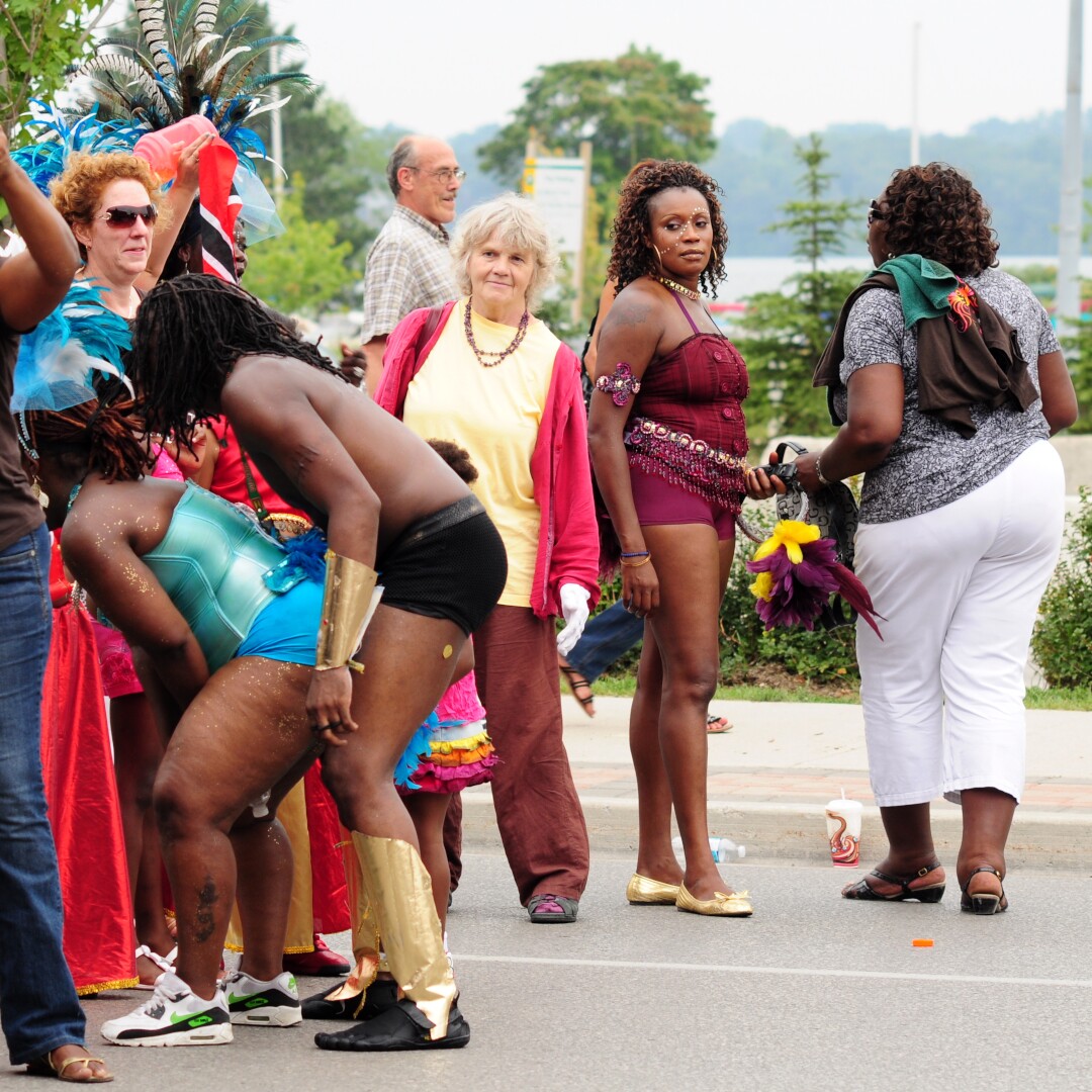 A Caribana celebrant looking askance at two other celebrants who are dancing in a risque way