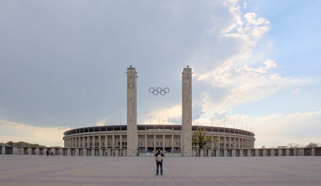 A man standing in front of the 1936 Olympiastadion in Berlin, Germany